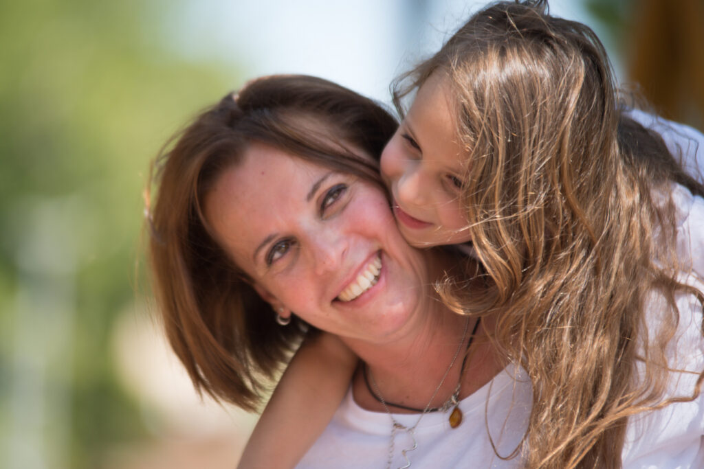 Ritratto di una mamma con la sua bambina sulle spalle